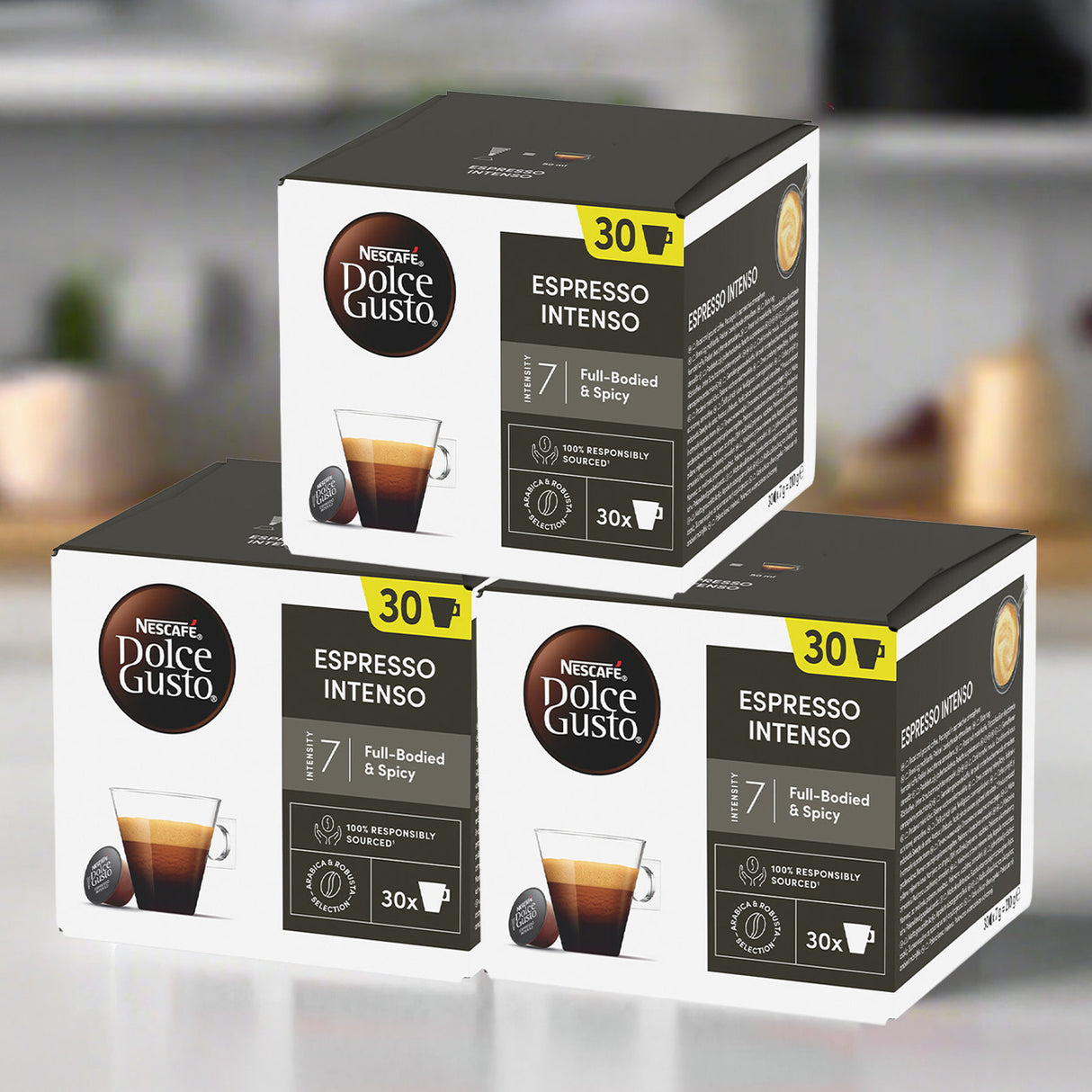 Three boxes of Nescafe Dolce Gusto Espresso Intenso coffee pods on a blurred kitchen background