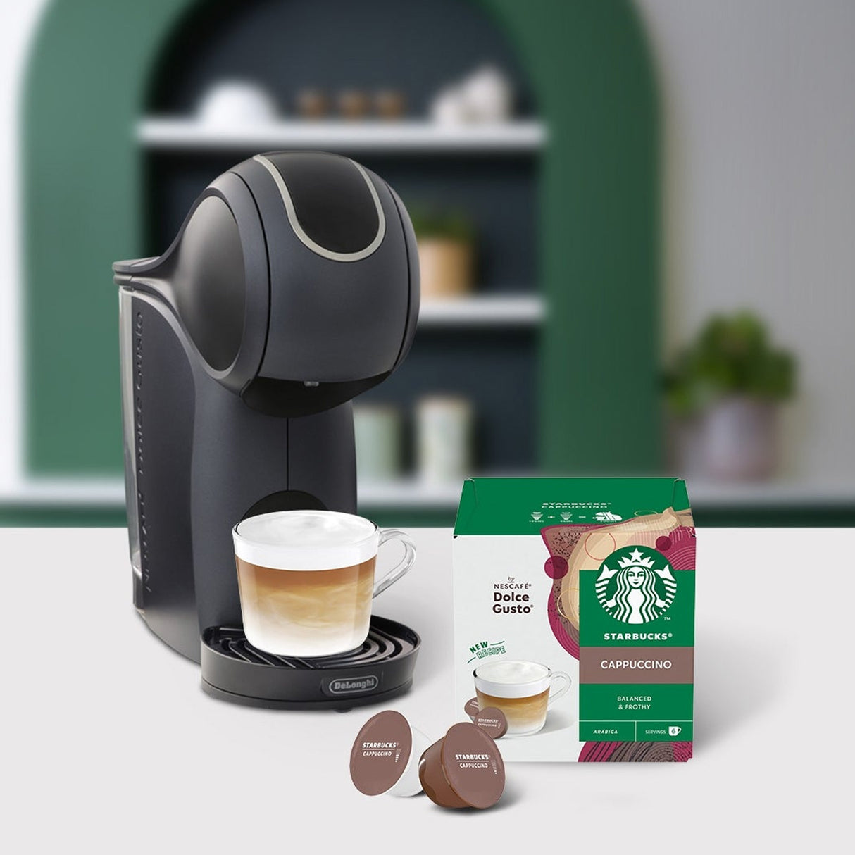 Black coffee machine with a cup of coffee and Starbucks coffee pods on a table.
