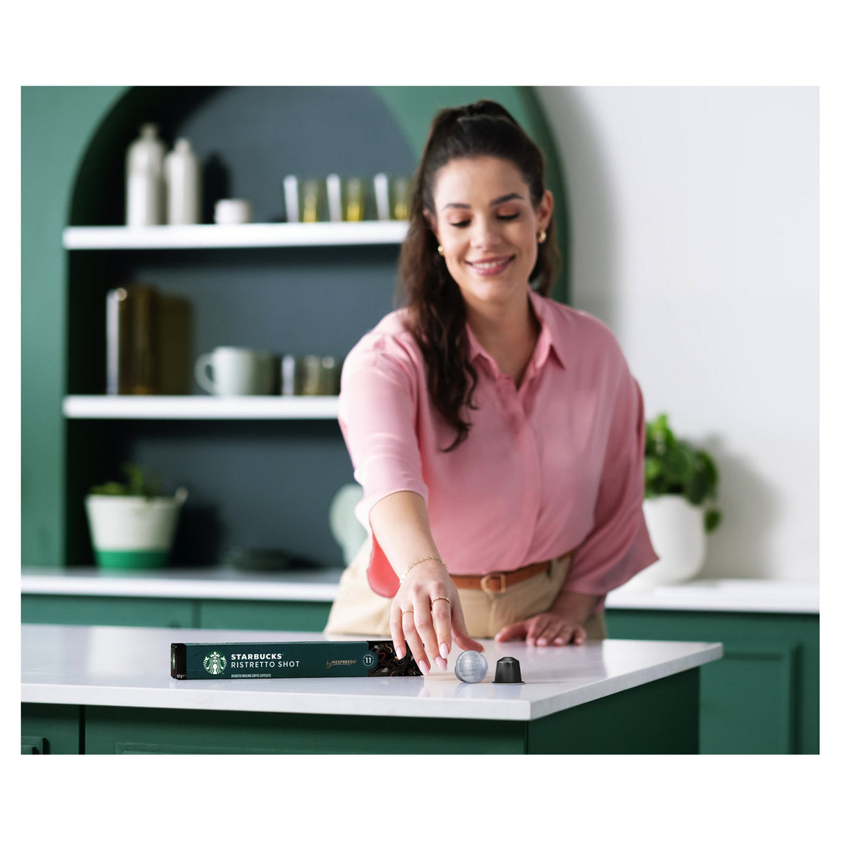 Woman in a kitchen setting with a Starbucks product on the counter