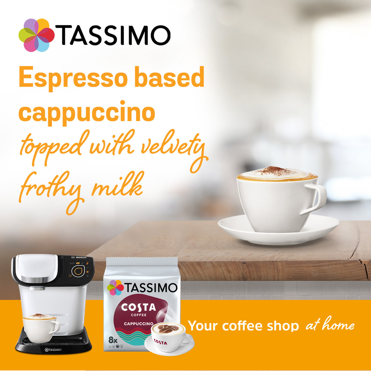 TASSIMO coffee machine, TASSIMO Costa coffee pack, and a cup of cappuccino on a table with a blurred background.