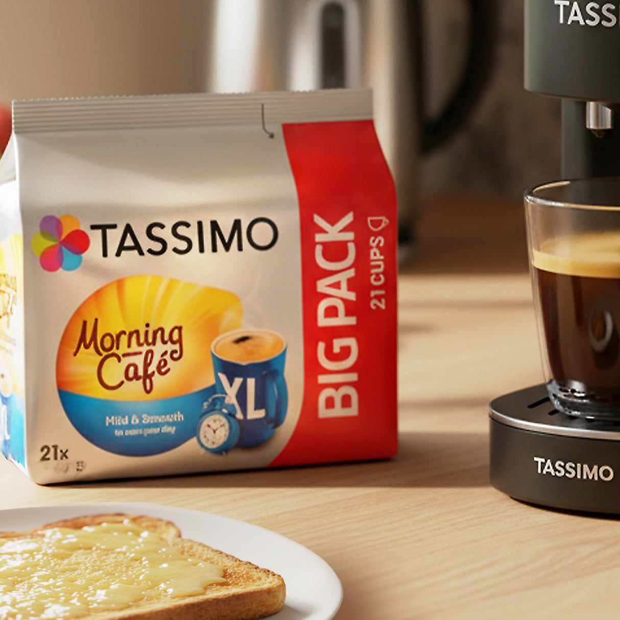 TASSIMO Morning Cafe Big Pack with a TASSIMO coffee machine and glass of coffee on a table.