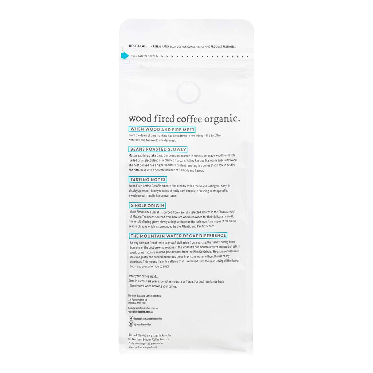 A resealable hang-sleeve pouch of Wood Fired Coffee Organic on a plain white background, showing the back of the packaging with text and a small blue leaf icon near the top.