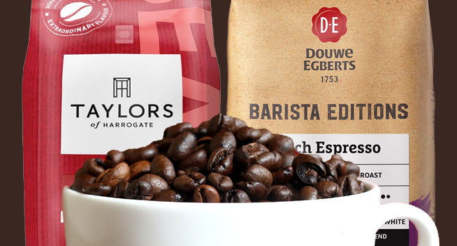 Cup full of Coffee Beans infront of a bag Taylors of harrogate coffee beans and Douwe egberts Barista Coffee Beans