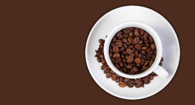 A cup filled with coffee Beans on a saucer