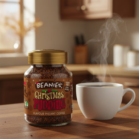 Jar of Beanies Christmas Pudding instant coffee with a steaming cup on a wooden table.