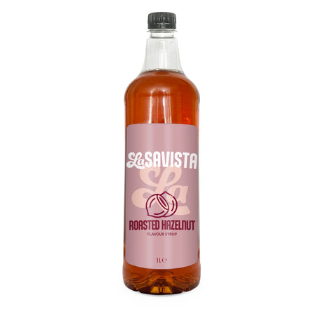 A 1L bottle of Savista Roasted Hazelnut flavour syrup, filled with a golden-brown liquid and featuring a dusty pink label with white and dark pink branding, set against a plain white background.