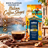 Lavazza Canal Grande Venezia Filter coffee bag displayed next to a steaming cup of espresso on a rustic wooden surface with coffee beans and chocolate pieces, with Italian-themed promotional text in the background.