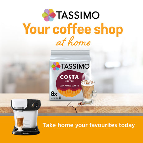 Tassimo coffee machine and Tassimo Costa Coffee packaging on a wooden surface with a blurred background.