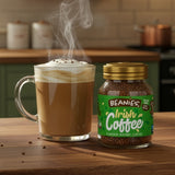 Steaming cup of coffee next to a jar of Beanies Irish Coffee on a wooden table.