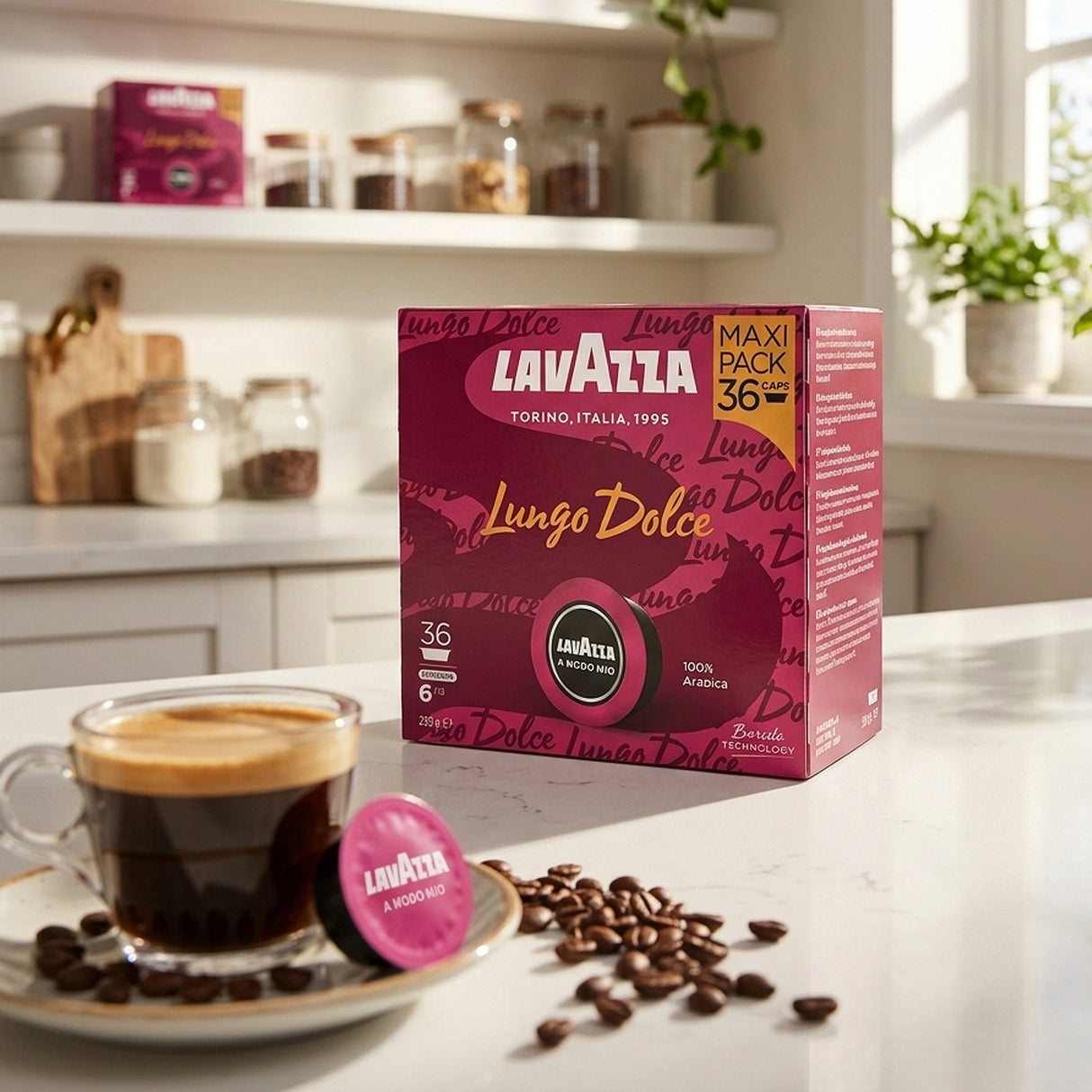 Lavazza Lungo Dolce coffee capsule box in a bright kitchen setting, with a cup of espresso, scattered coffee beans, and a loose capsule in the foreground.