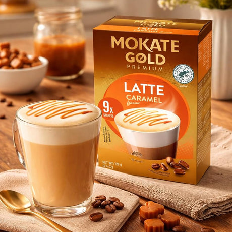 Mokate Gold Premium Latte Caramel coffee package with a glass of latte on a wooden table.