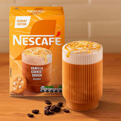 Nescafe Vanilla Cookie Dough Latte packaging with a cup of latte on a wooden surface