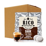 A bulk box of RICO Kaffepads dark coffee filter pods shown with a silver foil bag, a glass of espresso, and two loose filter pods on a white background.