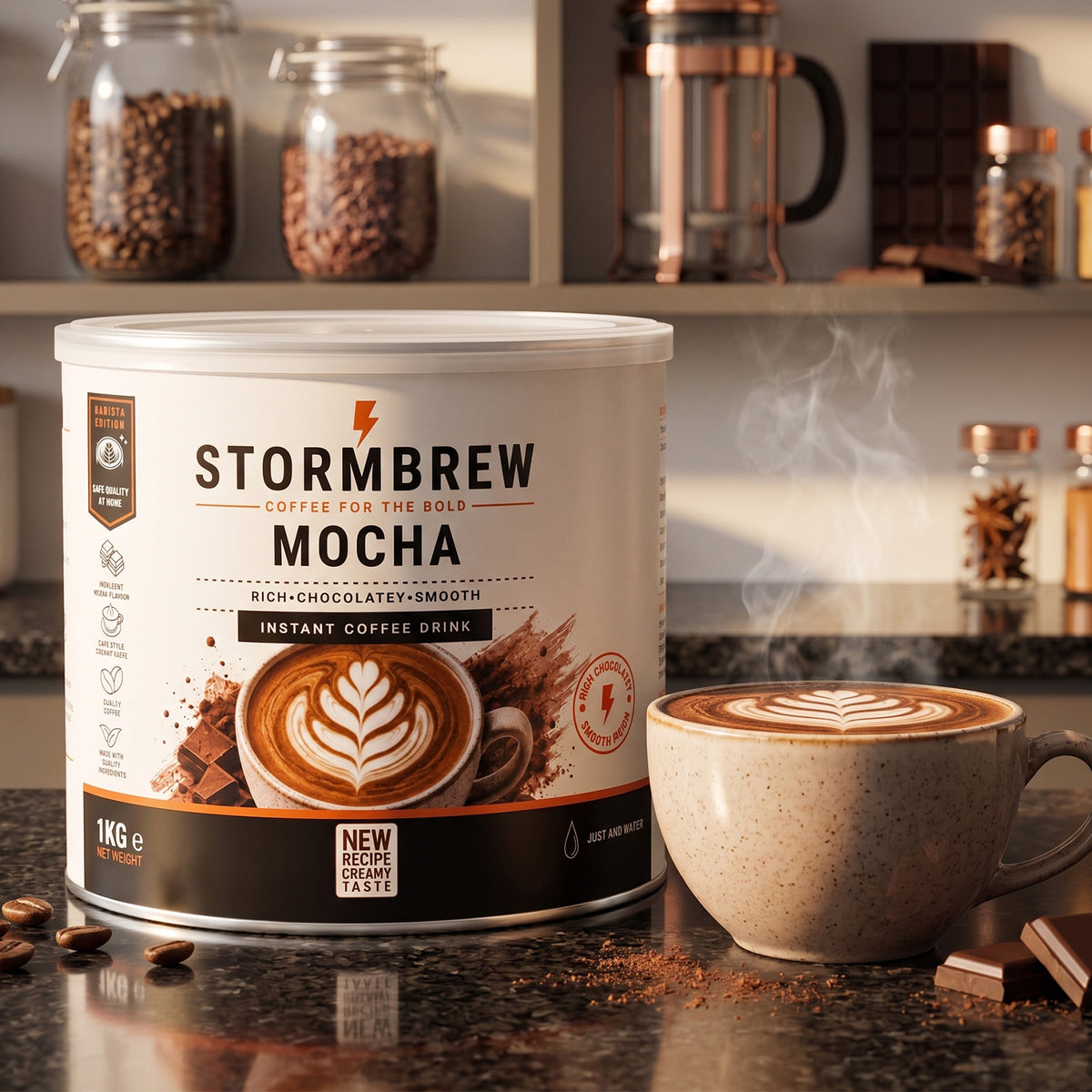 Stormbrew Mocha Instant Coffee Drink tin stands on a counter-top beside a ceramic mug filled with coffee and latte art, with coffee beans, jars, and chocolate bars visible in the background.