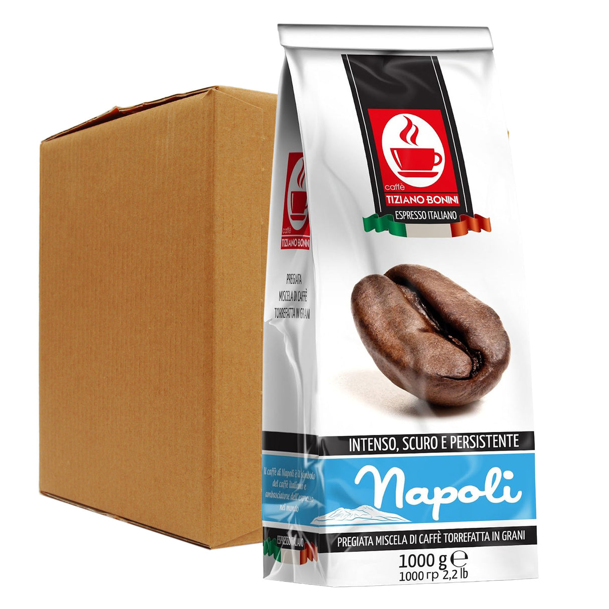 A 1000g bag of Napoli espresso coffee stands in front of a plain brown cardboard shipping box on a white background. The bag is white with a prominent red and black Napoli logo, a photo of roasted coffee beans, and blue brand lettering near the bottom.